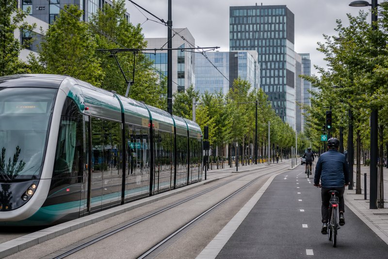 Urban mobility — electric tram and cyclists in a European city